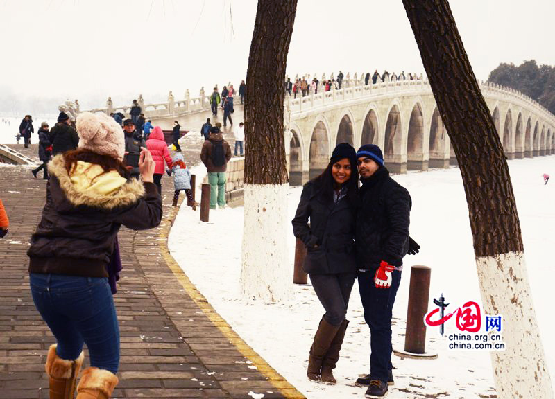 Le 20 janvier, des touristes étrangers pennent des photos près du pont aux Dix-Sept Arches enneigé. (Crédit photo: Zhu Ying)