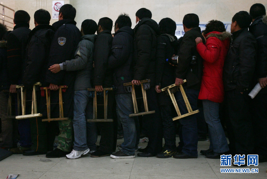 Les tabourets pliants. Le 9 janvier 2009 à la gare de Qingdao, tous les voyageurs qui achetaient leur billet de train avaient un tabouret pliant dans la main. 