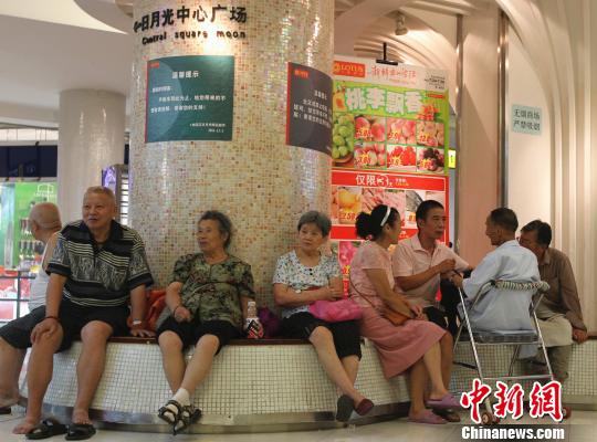 À Chongqing, le public profite de la fraîcheur d'un magasin.