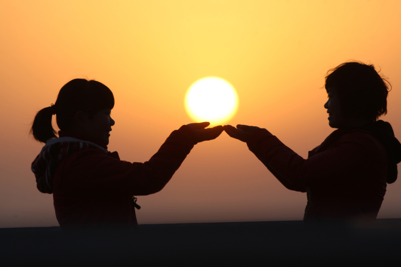 Le 1er janvier 2014, deux touristes célèbrent le Nouvel An sur le quai des Pêcheurs à Yantai, dans la province chinoise du Shandong.
