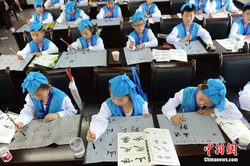 Un cours de calligraphie en tenue traditionnelle chinoise