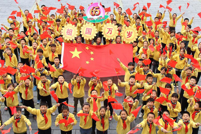 Des écoliers se prennent en photo avec le drapeau national à Jiaozuo, dans la province du Henan, le 30 septembre 2014. [Photo : Xinhua]
