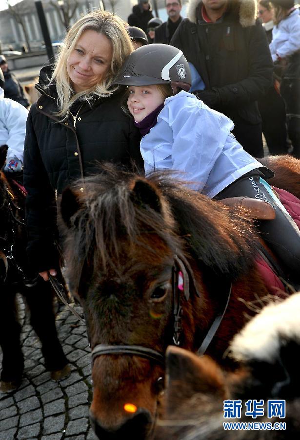 Le 1er janvier à Paris, une fillette qui participe au défilé sur un poney avec sa mère.