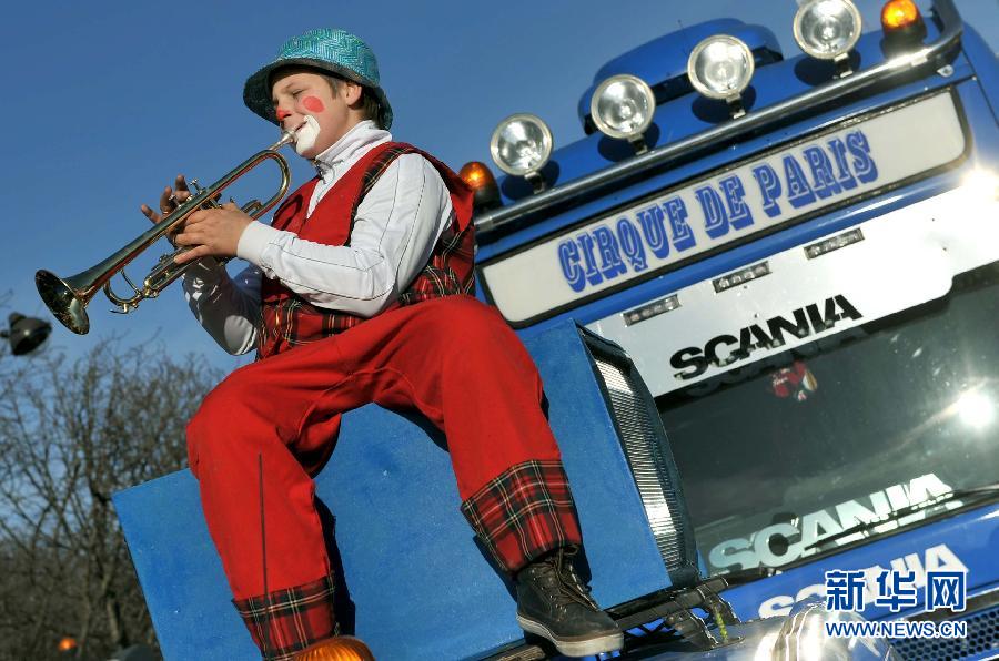 Le 1er janvier à Paris, un musicien de cirque joue de la trompette sur un camion.