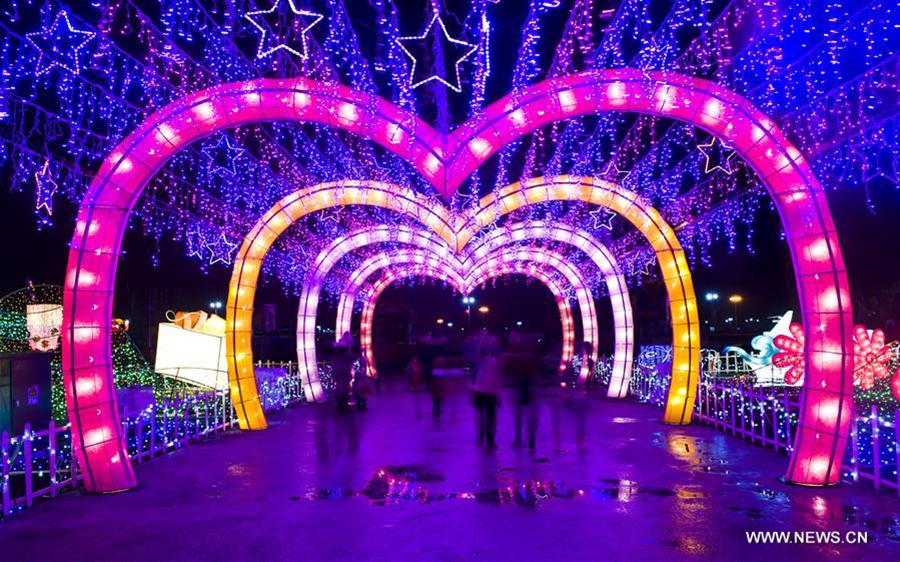 Photo prise le 29 janvier 2016 montrant des gens marchant sous des lanternes pendant une foire aux lanternes dans la ville de Zhenjiang, dans la province du Jiangsu (Est de la Chine). Cette foire aux lanternes, qui présente plus de 200 ensembles de lanternes du Jiangsu et de Taiwan (Sud-est de la Chine), a ouvert vendredi et durera 28 jours.