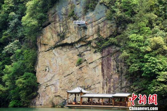 A capsule-like glass room, measuring 3.2 meters long and 1.6 meters wide, hangs from a cliff at Baohu Lake scenic spot in Zhangjiajie City, Central China&apos;s Hunan Province. (Photo/Chinanews.com) 