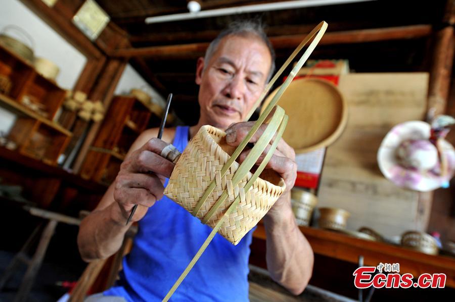 Lin Dengyan fabrique des œuvres en bambou dans sa boutique de la vieille ville de Songkou, dans le comté de Yongtai de la province du Fujian (est), le 5 juillet 2016.