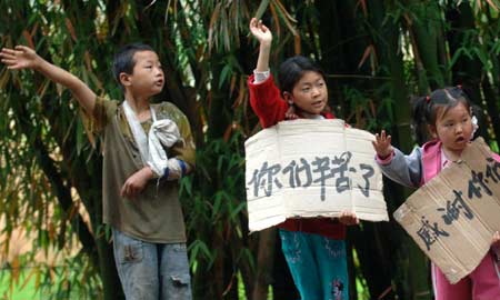 Kinder stehen mit Plakaten zum Ausdruck ihrer Dankbarkeit gegenüber den PLA-Soldaten und anderen Rettungskr?ften entlang der Autobahn.