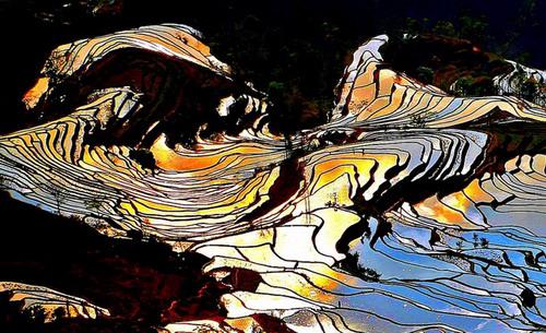 Man sagt, Yuanyang sei der beste Ort in Yunnan, um einen Sonnenuntergang zu fotografieren. Das Abendrot ist hier nicht nur im Himmel, sondern überall zu spüren. Der Wind singt dazu sein Lied und zieht über die bunten Terrassenfelder.