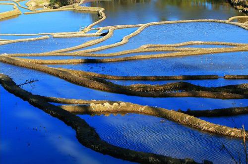 Man sagt, Yuanyang sei der beste Ort in Yunnan, um einen Sonnenuntergang zu fotografieren. Das Abendrot ist hier nicht nur im Himmel, sondern überall zu spüren. Der Wind singt dazu sein Lied und zieht über die bunten Terrassenfelder.