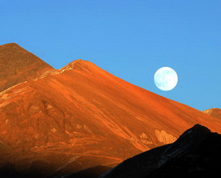 Auf einem Berg in Tibet haben am Mittwochabend die Sonne und der Mond gleichzeitig geschienen. Mit dem Sonnenschein in der Abenddämmerung sorgte der volle Mond über dem Berg für ein schönes Bild.