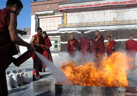 3 Tibetische buddhistische M?nche versuchen, bei einer übung im lamaistischen Kloster Zhaxi Lhunbo in Xigaze im südwestchinesischen Autonomen Gebiet Tibet ein Feuer zu l?schen