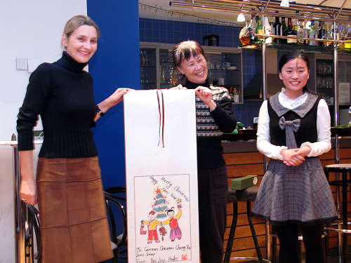 Birgit Baur-Gallizioli (links) nimmt ein Geschenk von zwei Beijing Huiling-Mitarbeitern entgegen