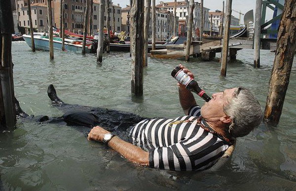 Ein Gondolier erfrischt sich bei 32 Grad Celsius mit einem Bier in einem Gartenstuhl im Gro?en Kanal von Venedig ab (5. August, REUTERS)