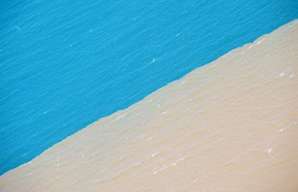 Der Luftblick zeigt verfärbtes braunes Flutwasser neben dem normalen blauen Wasser des Karibischen Meeres an der Küste der vom Sturm verwüsteten Stadt Gonaives auf Haiti (11. September, AFP/GETTY)