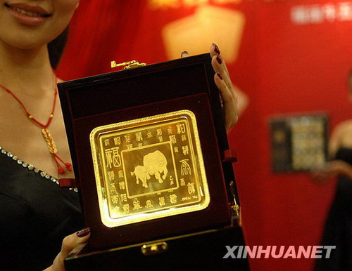 Ein Model zeigt einen Goldbarren namens 'Glückbringender Büffel' in einem Kaufhaus in Beijing.