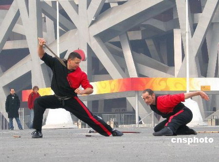 1 Einige Ausl?nder haben vor kurzem im Olympiapark vor dem 'Vogelnest', dem Nationalstadion, eine Vorführung in chinesischer Kampfkunst gegeben. Die Darbietung wurde eigens gefilmt und lockte viele Passanten an.