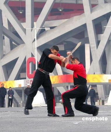 3 Einige Ausl?nder haben vor kurzem im Olympiapark vor dem 'Vogelnest', dem Nationalstadion, eine Vorführung in chinesischer Kampfkunst gegeben. Die Darbietung wurde eigens gefilmt und lockte viele Passanten an.