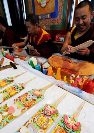 Tibetische Mönche gestalten in einem lamaistischen Tempel in Lhasa farbenfrohe Schilder. Diese Schilder aus Butter werden in die Qiema, eine zweistufige, rechteckige Holzschachtel, gelegt, die geröstete Gerste und aus Butter, Gerstenmehl und Zucker gemachtes Essen beinhaltet. Die Einheimischen treffen Vorbereitungen für das Tibetische Neujahr, das am 25. Februar gefeiert wird. 