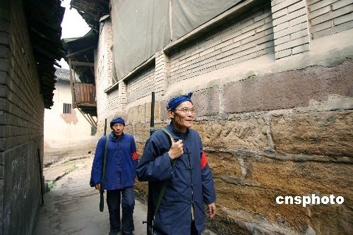 1 Zwei Patrouillen in Uniformen im Stil der 1930er Jahre marschieren durch die alten Stra?en von Songji in der südwestchinesischen Stadt Chongqing. Die mit Holzgewehren bewaffneten Patrouillen sind Teil des dortigen Kontrollprogrammes für die Nachbarschaft. Die Gemeinde wirbt mit ihnen au?erdem für touristische Zwecke.