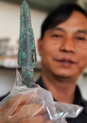 Ein Arch?ologe zeigt eine alte Bronzelanzette, die in den Jinlian-Bergen im Kreis Dengjiang in der südwestchinesischen Provinz Yunnan entdeckt worden ist 