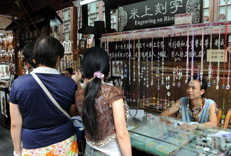 Volkskünstler Zhu Shixin demonstriert seine spezielle Eingravierungskunst auf Reis in der Jinli-Straße in Chengdu. (24. August 2009)
