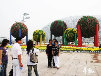 Touristen machen Fotos vor einer riesigen Dekoration beim Nationalstadion, dem Vogelnest, in der chinesischen Hauptstadt Beijing. Der Olympiapark, in dem sich das Vogelnest befindet, wurde zur Feier des 60. Jahrestags der Gründung der Volksrepublik China für den 1. Oktober in Schale geworfen. [Foto von Hu Junfeng]