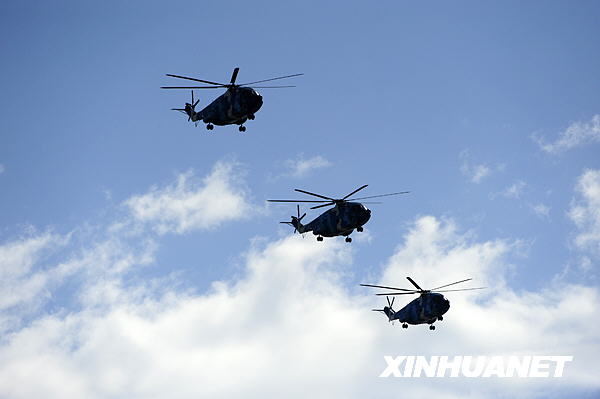 Kampfhubschrauber fliegen im Verband über den Tian’anmen-Platz