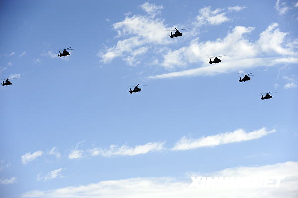 Kampfhubschrauber fliegen im Verband über den Tian’anmen-Platz