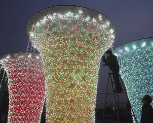 Zwei Arbeiter arrangieren die Lichterketten an den Laternen im Sunshine Valley. Alle Lichterketten-Laternen zur Dekoration der Shanghaier Expo sind nun fertig, so dass die Probebeleuchtung in Yangzhou in der ostchinesischen Provinz Jiangsu beginnen kann (4. Februar 2010). Die Lichterketten-Laternen werden auf der Laternenausstellung zum Chinesischen Neujahr im Yuyuan-Garten von Shanghai ausgestellt.