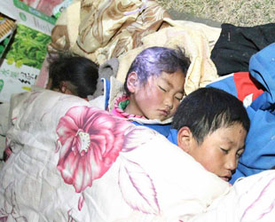 Drei Kinder schlafen im Freien in der Nacht des 14. April im Erdbebengebiet Yushu. Um 7.49 Uhr des selben Tages hat ein Erdbeben der Stärke 7.1 auf der Richterskala den Kreis Yushu im Tibetisch-Autonomen Bezirk Yushu in der nordwestchinesischen Provinz Qinghai erschüttert.