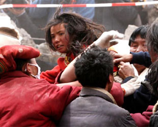 Ein 13-jähriges tibetisches Mädchen wird von Mönchen des Yushu Jiegu-Tempels und China International Search aus den Trümmern gerettet.