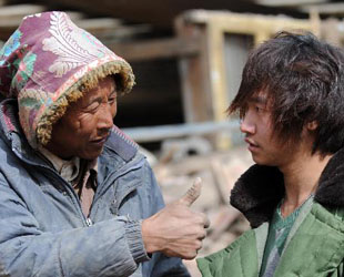 Ein Tibeter lobt den 23-jährigen Yang Yang (rechts), der sieben Menschenleben aus den Trümmern des Erdbebens in der Stadt Gyegu in der nordwestchinesischen Provinz Qinghai rettete; 17. April 2010.