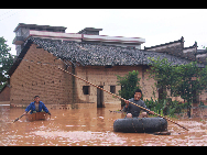 Dorfbewohner paddeln in Booten im überfluteten Dorf Taihe, das zur Gemeinde Yicheng in Zhangshu in der ostchinesischen Provinz Jiangxi gehört (22. Mai 2010). Seit Freitag suchen heftige Regenstürme die ohnehin in letzter Zeit stark von Regen betroffene Provinz Jiangxi heim und verursachen Überflutungen in vielen Gegenden. Mindestens 1,46 Millionen Menschen sind von der Katastrophe betroffen, und über 40.000 Menschen sind notfallmäßig evakuiert worden. [Xinhua]