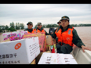 Die bewaffnete Polizei transportiert Hilfsgüter ins Dorf Shitou, das zur Gemeinde Zhongzhou in Zhangshu in der ostchinesischen Provinz Jiangxi gehört (22. Mai 2010). [Xinhua]