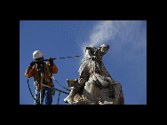 Ein Arbeiter säubert in Cape Town, das sich auf die WM 2010 vorbereitet, eine Statue zum Gedenken an die Menschen, die im Anglo-Boer-Krieg ums Leben kamen (29. April 2010). [China Daily/Agenturen]