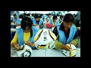 Fließbandarbeiter der Jiujiang Simaibo Sports Equipment Corporation Ltd. in Jiujiang in der ostchinesischen Provinz Jiangxi nähen den offiziellen Ball der Fußball-WM 2010 (7. Mai 2010). [China Daily/Agenturen]