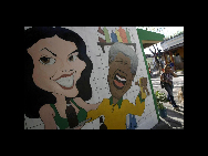 Ein Bewohner geht an einem Wandgemälde des ehemaligen südafrikanischen Präsidenten Nelson Mandela zur Feier der in Kürze stattfindenden WM 2010 im Wohnviertel eines Vororts von Rio de Janeiro vorbei (7. Juni 2010). [China Daily/Agenturen]
