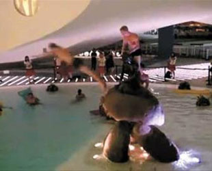Einige Angestellte des dänischen Expo-Pavillons wurden gesehen, als sie im Wasserbecken schwammen, das die berühmte Skulptur 'Kleine Meerjungfrau' umgibt.