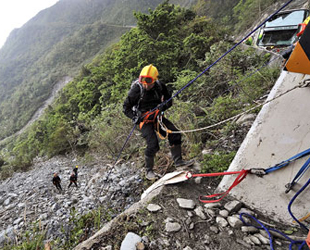Rettungsarbeiter suchen in einer Schlucht in Taiwan zwanzig Touristen vom chinesischen Festland, die nach dem Taifun Megi wahrscheinlich in ihrem Reisebus von einer Küstenstraße abgestürzt sind.