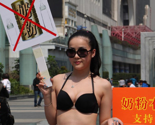 Drei chinesische Frauen in Bikini standen am Freitag mit Schildern in Shenzhen. Auf den Schildern sind Slogans zu lesen: 'Begrenztes Milchpulver, grenzenlose Mutterliebe' und 'Muttermilch statt importierter Milch'.