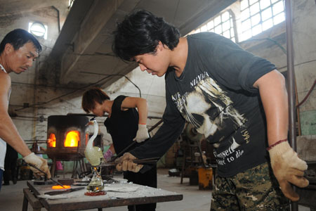 Obwohl zurzeit eine Hitzewelle herrscht, bemühen sich die Arbeiter des Farbglasur-Herstellers Panyang in der Stadt Zibo (Provinz Shandong, Ostchina) um die Produktion, damit die Bestellungen rechtzeitig abgewickelt werden können.