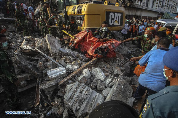 Security members work at the crash site of an Indonesian military plane Hercules C-130 in the capital of North Sumatra province Medan, Indonesia, on June 30, 2015. 