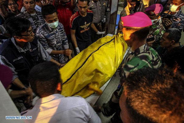 Security members transfer the body of a victim after the crash of an Indonesian military plane Hercules C-130 in the capital of North Sumatra province Medan, Indonesia, on June 30, 2015. 