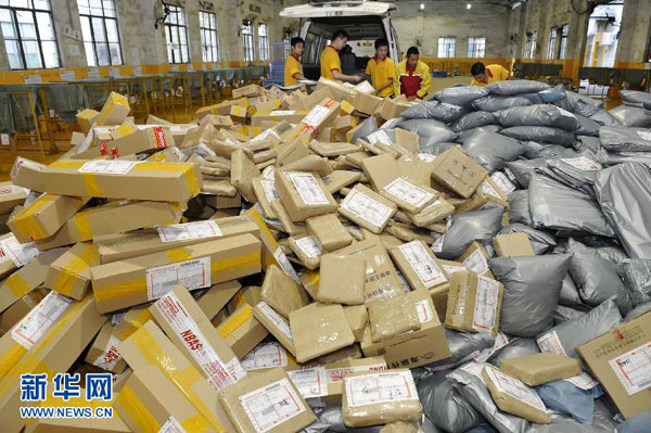 Staff members at an express delivery company in Guangzhou, south China's Guangdong province, are busy arranging the packages on Monday, November 11, 2013. [Photo: Xinhua/Liang Xu] 