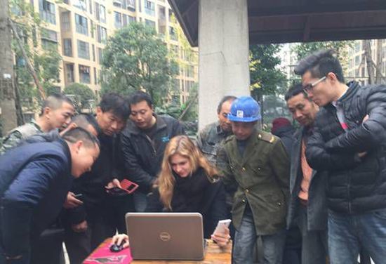 Junge Frau aus Ukraine hilft chinesischen Wanderarbeitern beim Online-Zugticketkauf