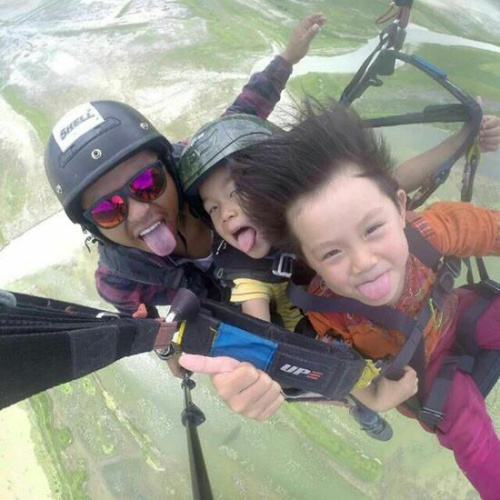 Pan Tufeng takes his daughter Wenwen(right) and his son Boru(middle) paragliding in Nepal. 