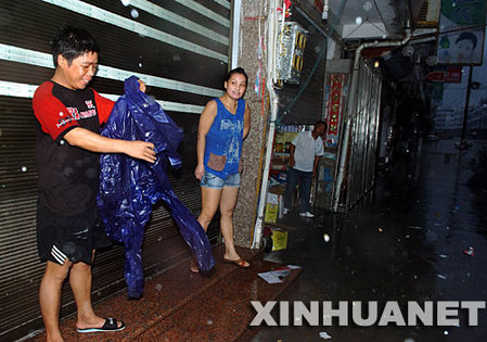 10月7日，福鼎沙埕镇居民在屋檐下躲避台风。当日15时40分，福建省气象台发布台风橙色预警信号称，台风“罗莎”于15时30分在闽浙交界的福鼎市沙埕镇登陆。     新华社记者姜克红摄 