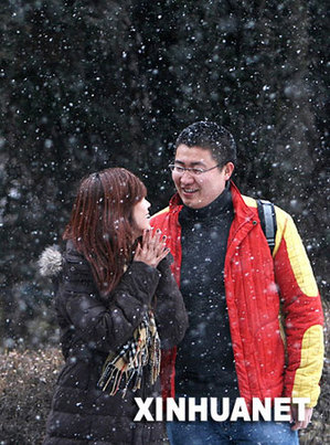 11月19日，一对情侣行走在飘雪的哈尔滨街头。当日，冰城哈尔滨降下2007年冬的第一场雪。 新华社记者 高增双 摄 