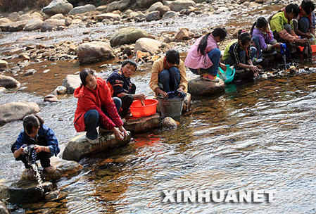 11月26日，在广西融水苗族自治县红水乡良双村完小，留守儿童在小溪里洗衣服。